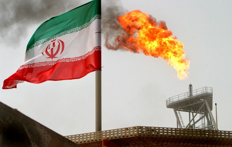 &copy; Reuters. FILE PHOTO: A gas flare on an oil production platform is seen alongside an Iranian flag in the Gulf