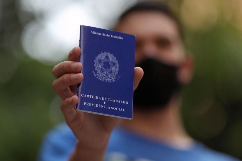 © Reuters. Homem mostra carteira de trabalho ao procurar oportunidade de emprego no centro de São Paulo