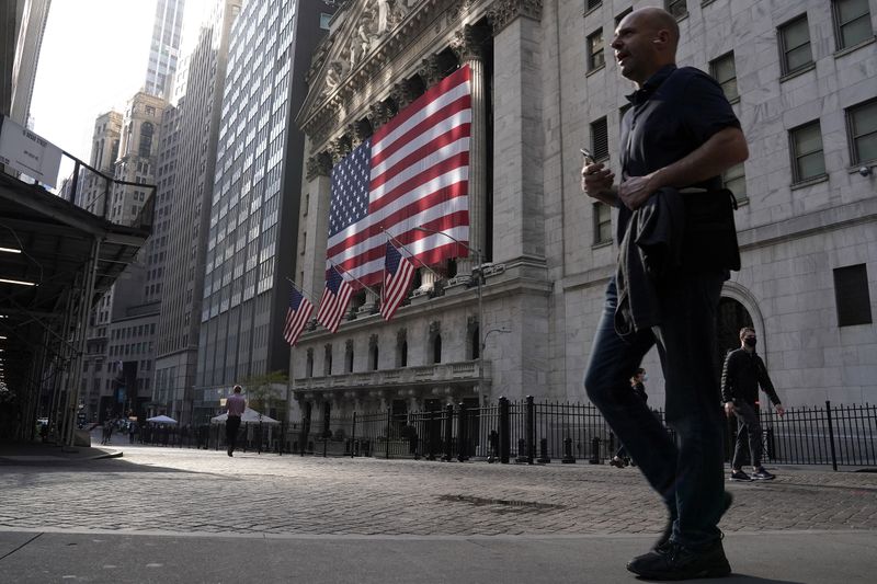 © Reuters. FILE PHOTO: People walk past the New York Stock Exchange