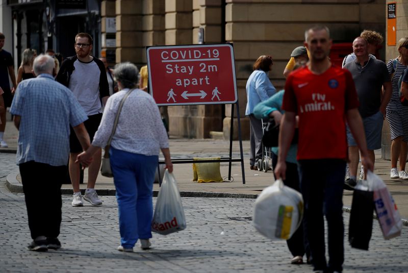 &copy; Reuters. FILE PHOTO: Shoppers walk past a social distancing sign following the outbreak of the coronavirus disease (COVID-19) in Chester, Britain