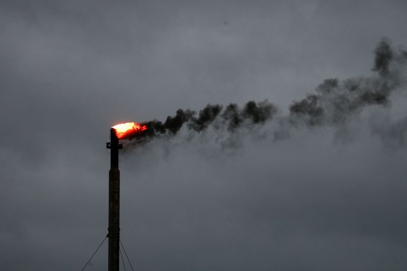 © Reuters. FILE PHOTO: Clouds from Hurricane Harvey are seen in the background as smoke rises from a burn off at an oil refinery in Corpus Christi