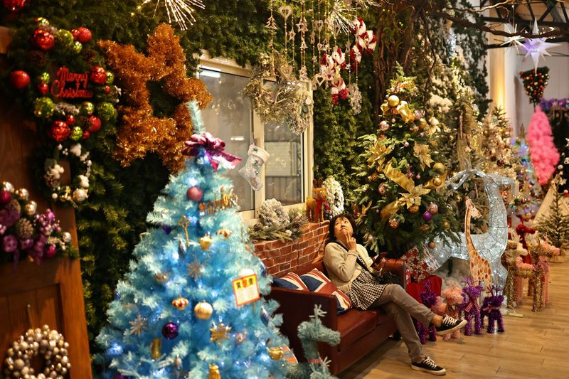 © Reuters. FILE PHOTO: A customer tries to decide which decoration to purchase at the salesroom of Lien Teng Enterprise in Taichung