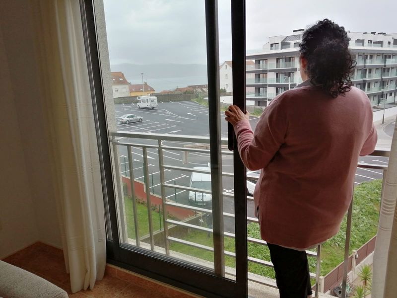 &copy; Reuters. Airbnb host Perla Requejo stands at the window of the property that she rents to holidaymakers on Airbnb in Sanxenxo