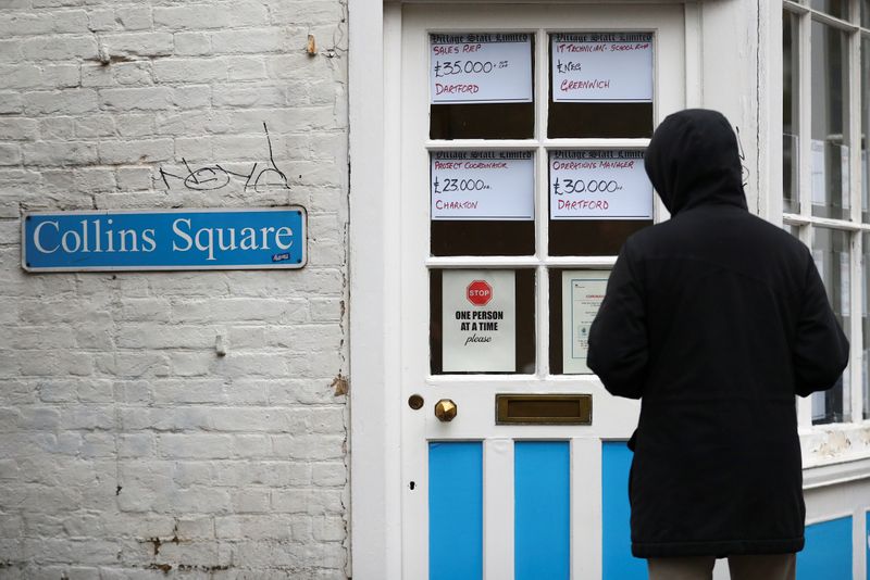 &copy; Reuters. A person looks at adverts in the window of a job agency in London