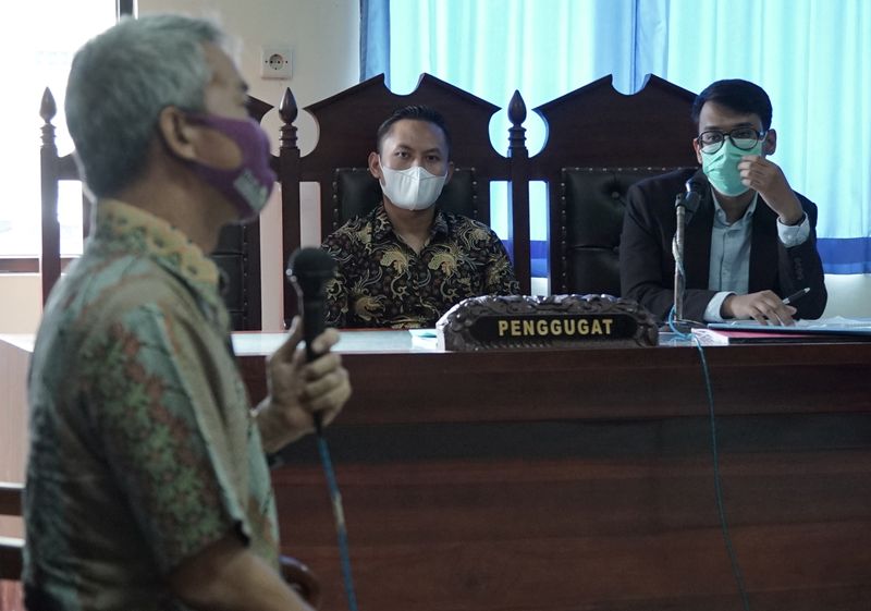 © Reuters. Tri Teguh Pujianto, a 31-year-old former police brigadier who was fired in 2018, sit with his laywer Maruf Bajammal while hearing a witness Siswanto, a psycology lecturer from Soegijapranata University, during his trial at a court in Semarang