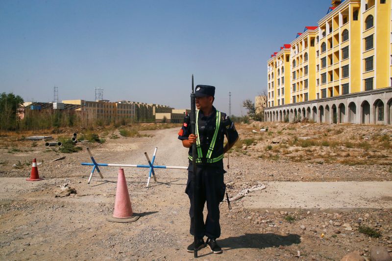 &copy; Reuters. FILE PHOTO: A Chinese police officer takes his position by the road near what is officially called a vocational education centre in Yining