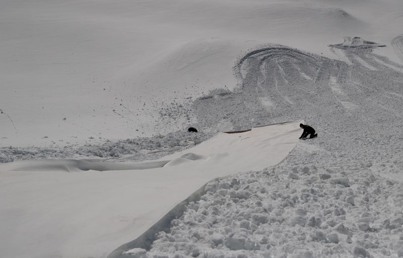 &copy; Reuters. FOTO DE ARCHIVO. Un trabajador ajusta una tela para cubrir la nieve de un glaciar en la estación de esquí del glaciar Stubaier cerca de Neustift im Stubaital