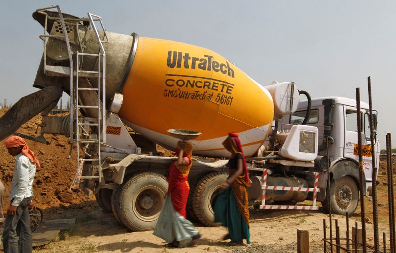 &copy; Reuters. FILE PHOTO: Workers walk in front of an UltraTech concrete mixture truck at the construction site of a commercial complex on the outskirts of  Ahmedabad