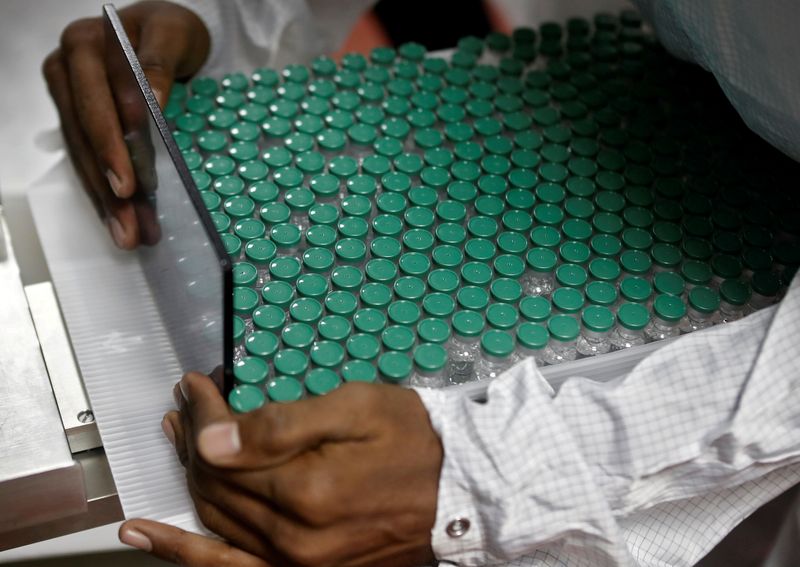 &copy; Reuters. FILE PHOTO: An employee in personal protective equipment (PPE) removes vials of AstraZeneca&apos;s COVISHIELD, coronavirus disease (COVID-19) vaccine from a visual inspection machine inside a lab at Serum Institute of India, in Pune