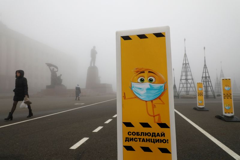 &copy; Reuters. Pedestrians walk past social distancing signs placed near a skating rink amid the coronavirus disease outbreak in Stavropol