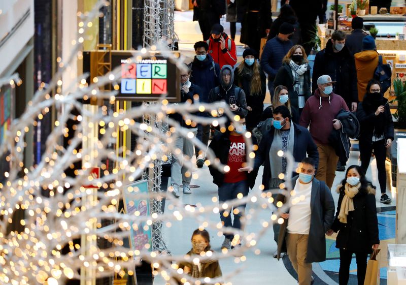 &copy; Reuters. FILE PHOTO: People wear protective face masks as they walk beside Christmas decoration amid the coronavirus disease (COVID-19) outbreak in Berlin