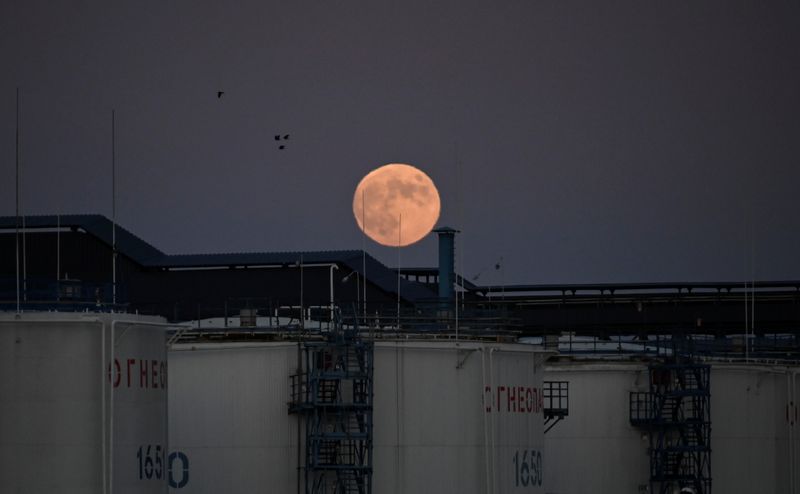 © Reuters. The moon rises behind oil storage tanks in Omsk