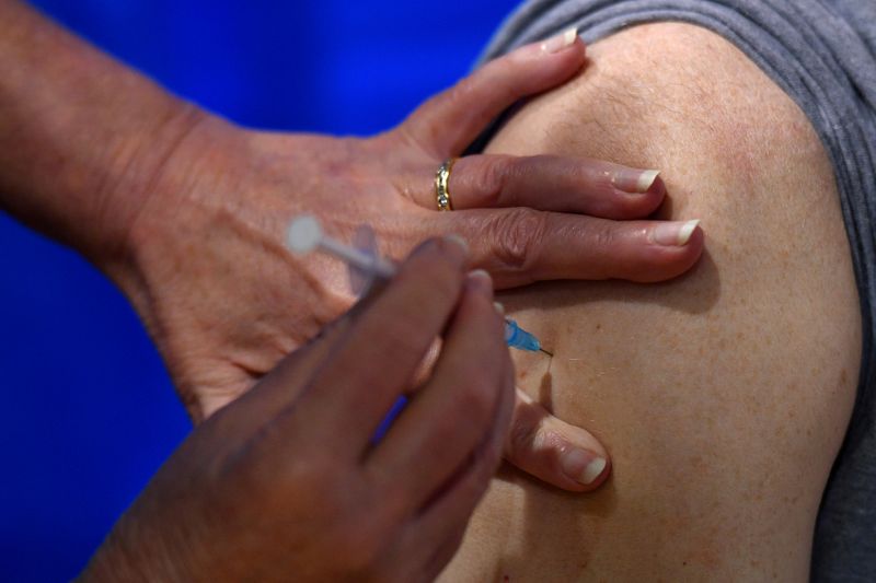 © Reuters. FILE PHOTO: A nurse administers the Pfizer/BioNTech COVID-19 vaccine to a man at a vaccination centre in Cardiff