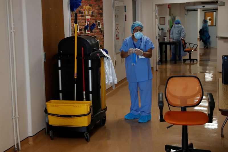 &copy; Reuters. A hospital housekeeper at Roseland Community Hospital looks down before cleaning at the hospital on the South Side of Chicago