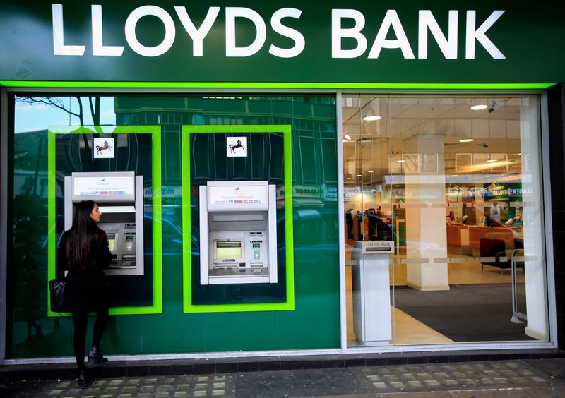 © Reuters. FILE PHOTO: A woman uses a cash machine at a Lloyds Bank branch in central London