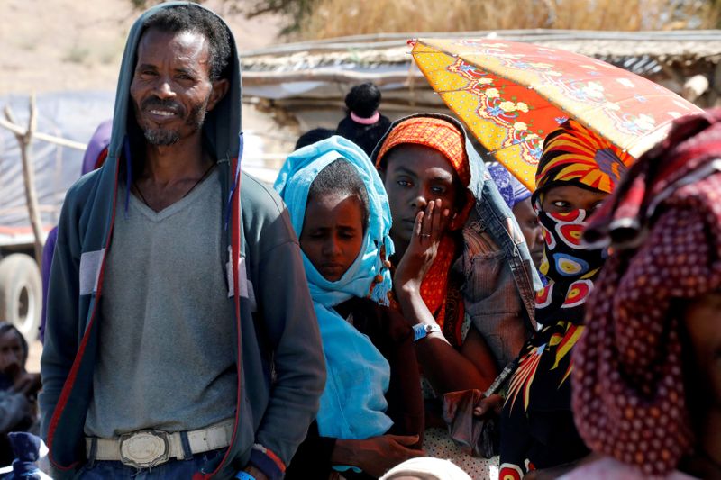 © Reuters. FILE PHOTO: People wait in line for food aid from the WFP, at the Um Rakuba refugee camp which houses Ethiopians fleeing the fighting in the Tigray region