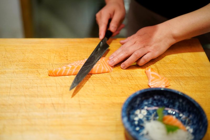 &copy; Reuters. Lai Yun, chefe e proprietário de um restaurante em Wuhan, na China, prepara salmão quase um ano depois do início do surto de coronavírus na cidade