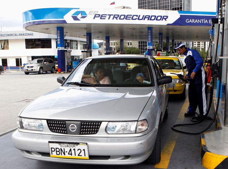 &copy; Reuters. FILE PHOTO: A worker pumps fuel into a car at a Petroecuador gas station in Quito