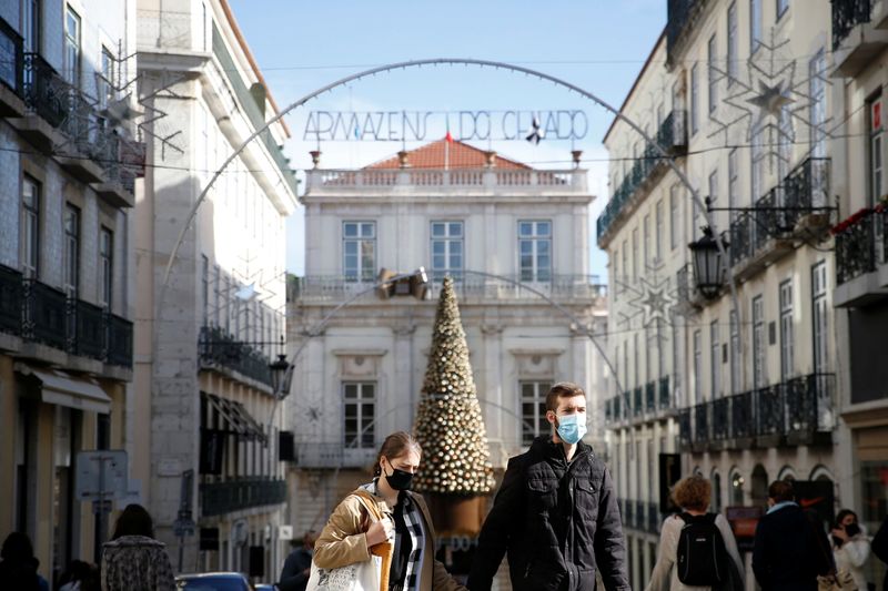 &copy; Reuters. Pessoas de máscara em rua de Lisboa