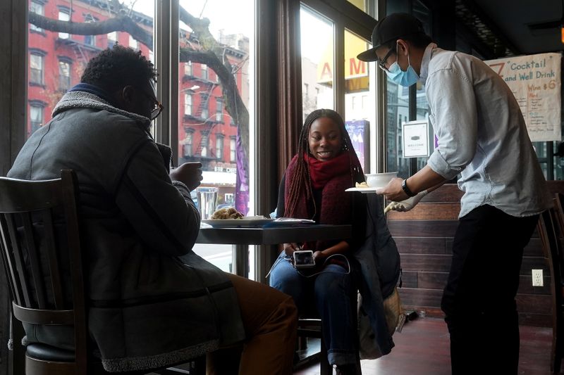 &copy; Reuters. A server brings food to a table in a restaurant in the Manhattan borough of New York City