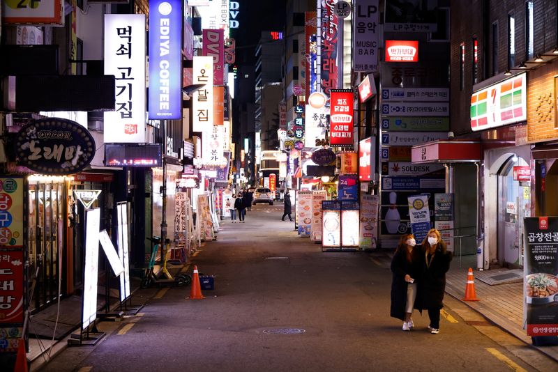 &copy; Reuters. Women walk on an empty street affected by heightened social distancing rules amid the coronavirus disease (COVID-19) pandemic in Seoul