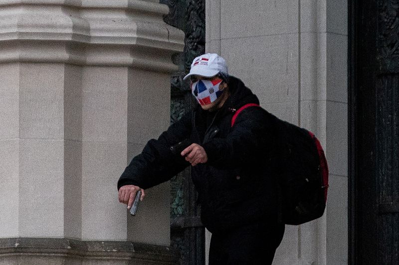 &copy; Reuters. A man wearing a protective mask points his guns outside the Cathedral Church of St. John the Divine in Manhattan