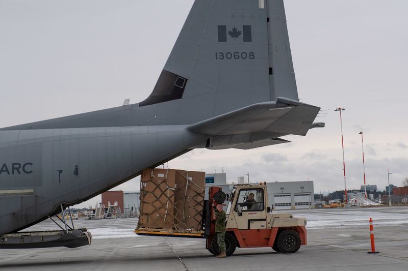 © Reuters. FILE PHOTO: Canadian Armed Forces personnel load special freezers for coronavirus disease vaccines onto aircraft pallets near the Ottawa Airport