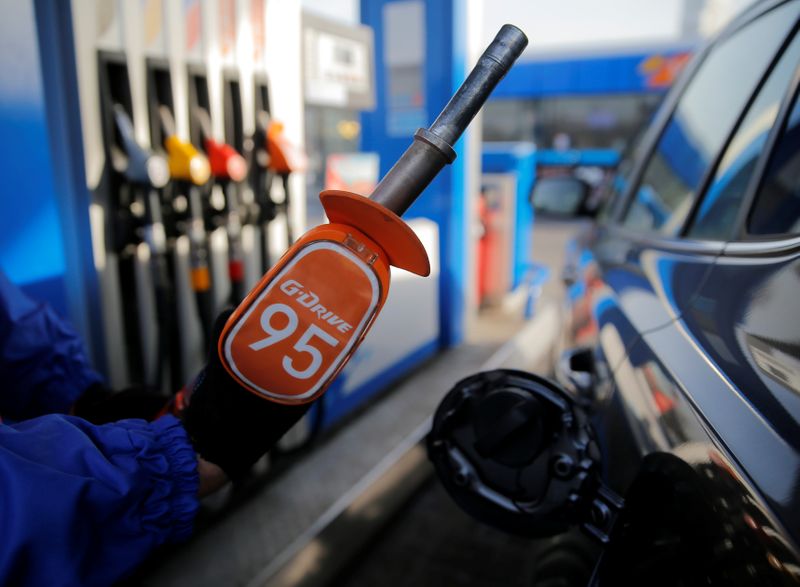 &copy; Reuters. Worker holds fuel nozzle at Gazprom Neft petrol station in Moscow