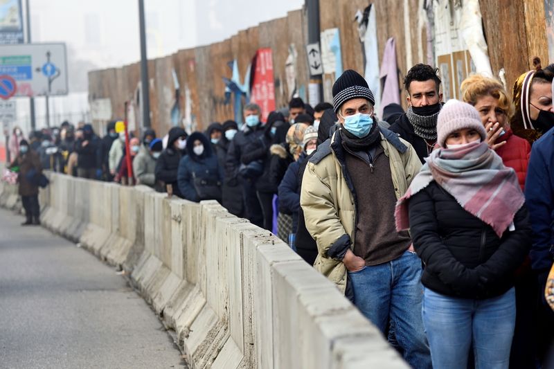 © Reuters. Queues of people waiting for food handouts in Milan