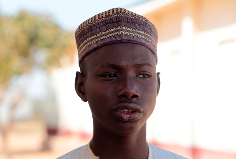 © Reuters. Muhammed Abubakar, a 15-year-old boy who escaped from men who kidnapped hundreds of students from his school, looks on in Kankara