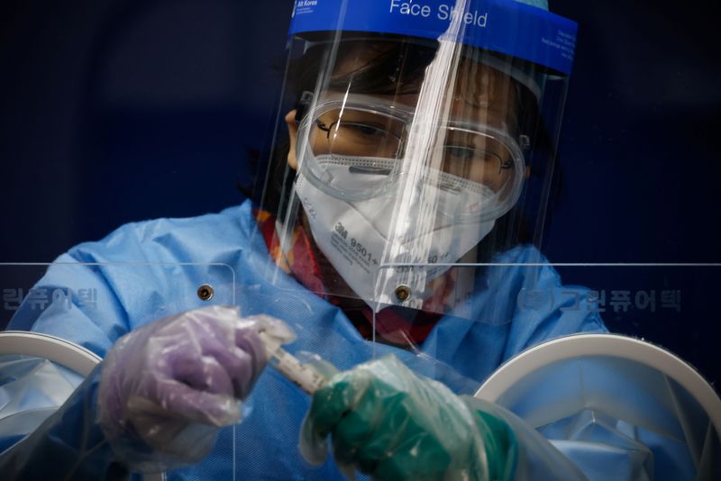 &copy; Reuters. A medical worker seals a coronavirus disease (COVID-19) test kit in Seoul