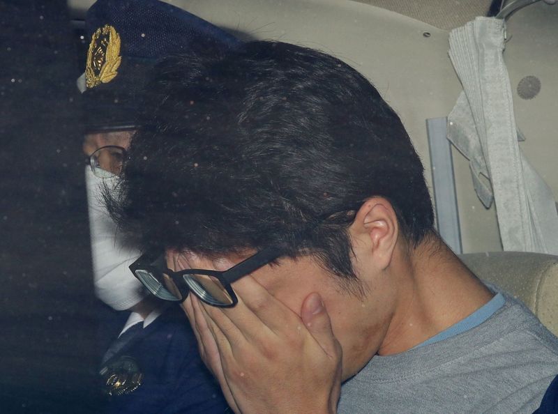 &copy; Reuters. Takahiro Shiraishi covers his face inside a police car in Tokyo