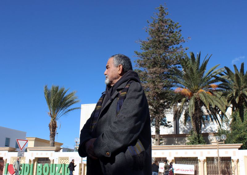 &copy; Reuters. Philosophy teacher Athmouni looks on as he stands along a street in Sidi Bouzid