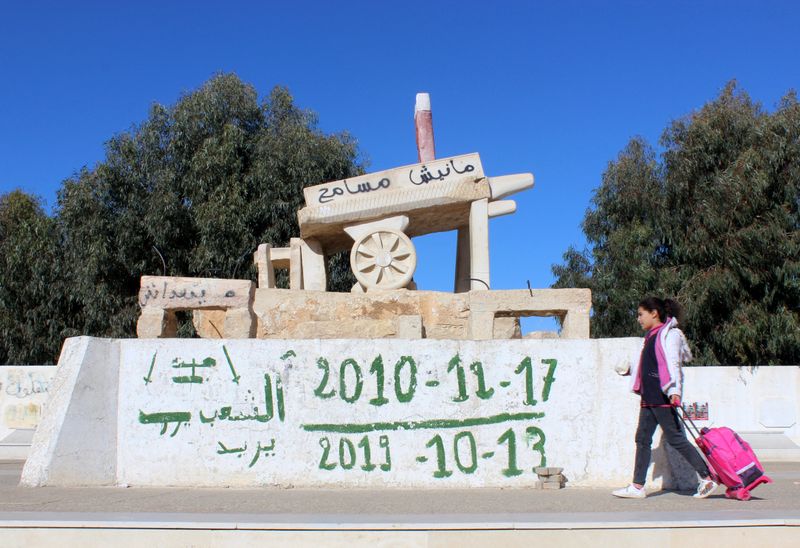 © Reuters. Girl walks past a memorial for Bouaziz in Sidi Bouzid