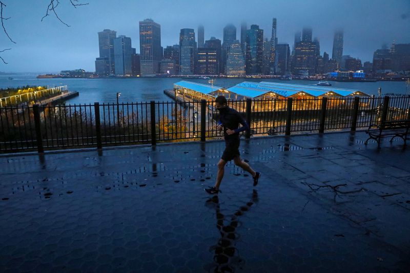 &copy; Reuters. FILE PHOTO: A man runs along the Brooklyn Heights Promenade as fog covers lower Manhattan in New York