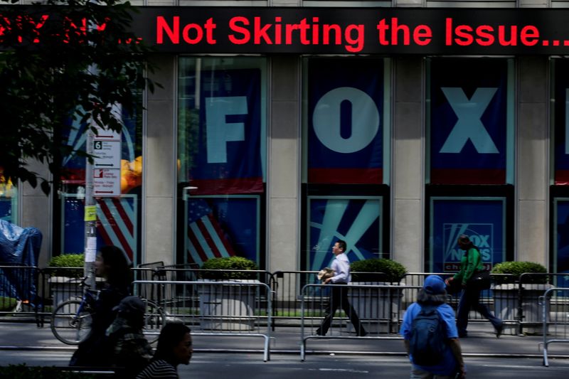 &copy; Reuters. FILE PHOTO: People pass by ads of Fox News channel at the News Corporation building in New York City