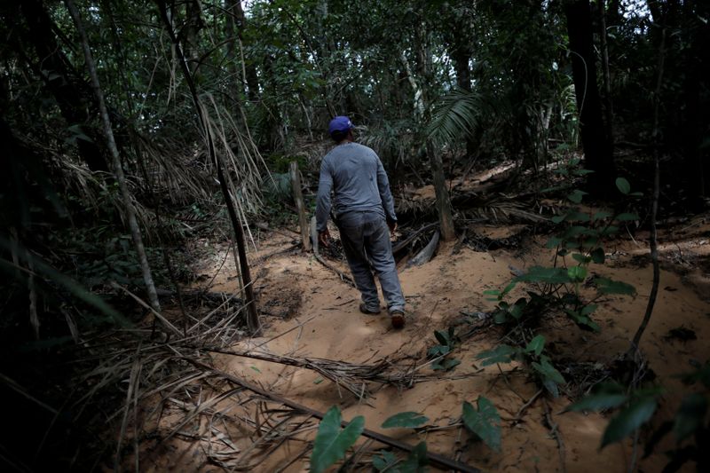 &copy; Reuters. IMAGEN DE ARCHIVO. El agricultor Valdineiz Pereira camina sobre la arena que ha invadido el agua de manantial dentro del área de Cerrado en una granja cerca de Barra do Ouro, Brasil