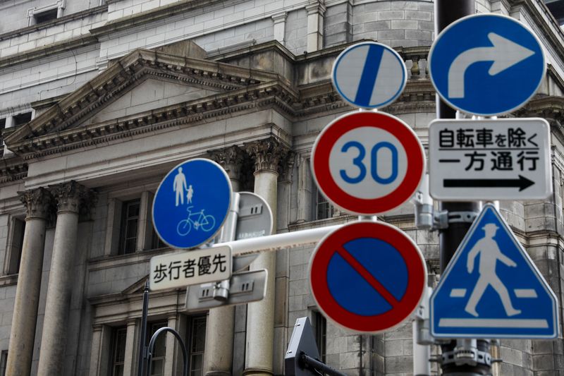 &copy; Reuters. FILE PHOTO:  Traffic signs are seen in front of the headquarters of Bank of Japan amid the coronavirus disease (COVID-19) outbreak in Tokyo