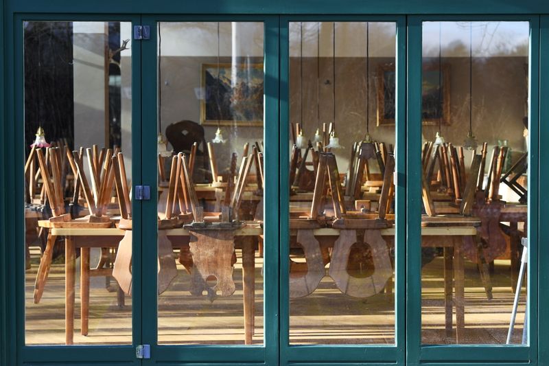 &copy; Reuters. Chairs are seen put onto tables upside down at a closed restaurant as the spread of the coronavirus (COVID-19) disease continues in Munich