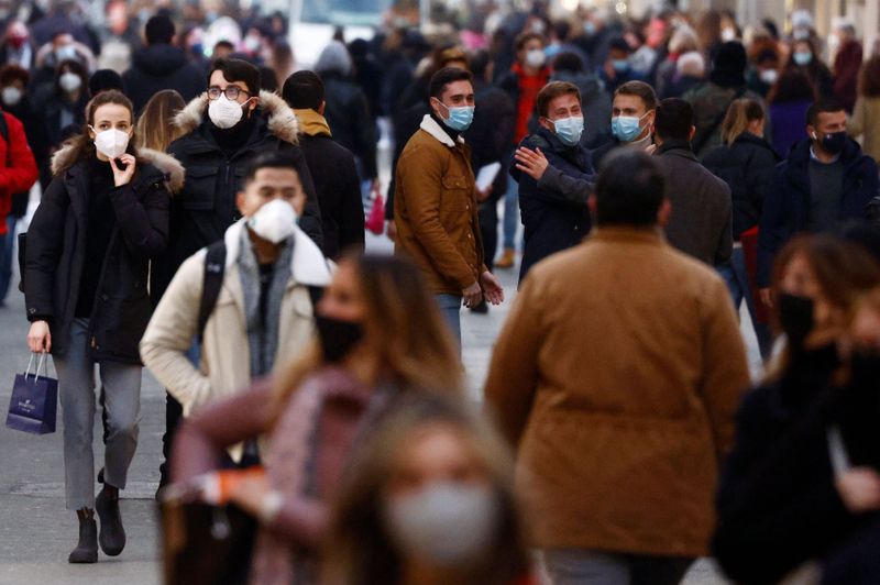 &copy; Reuters. Pessoas usando máscaras caminham em distrito comercial de Roma durante pandemia de Covid-19