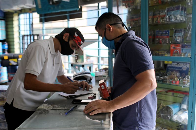 &copy; Reuters. Physical education teacher Victor Carrillo buys supplies at a shop in Caracas