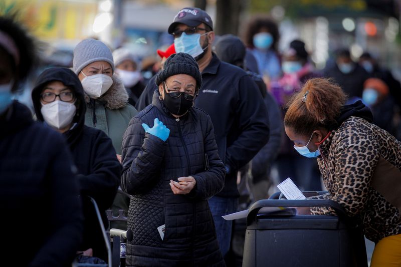 © Reuters. Pessoas usando máscaras fazem fila para receber alimento em Nova York