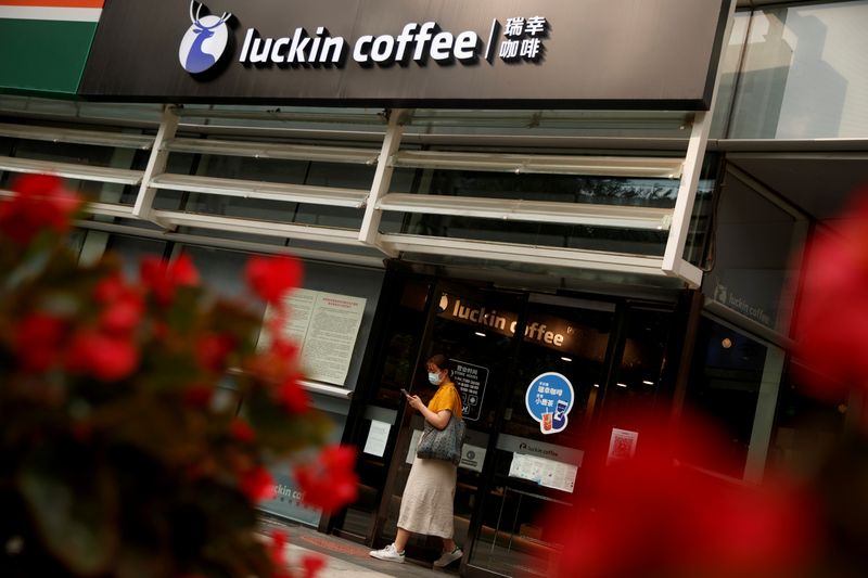 © Reuters. FILE PHOTO: A woman leaves a store of the Chinese coffee house chain Luckin Coffee in Beijing