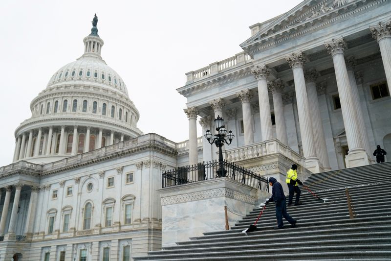 © Reuters. Workers shovel snow from the steps of the U.S. Capitol in Washington