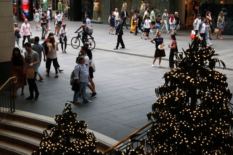 &copy; Reuters. People walk through a shopping plaza decorated for the holidays in the city centre of Sydney