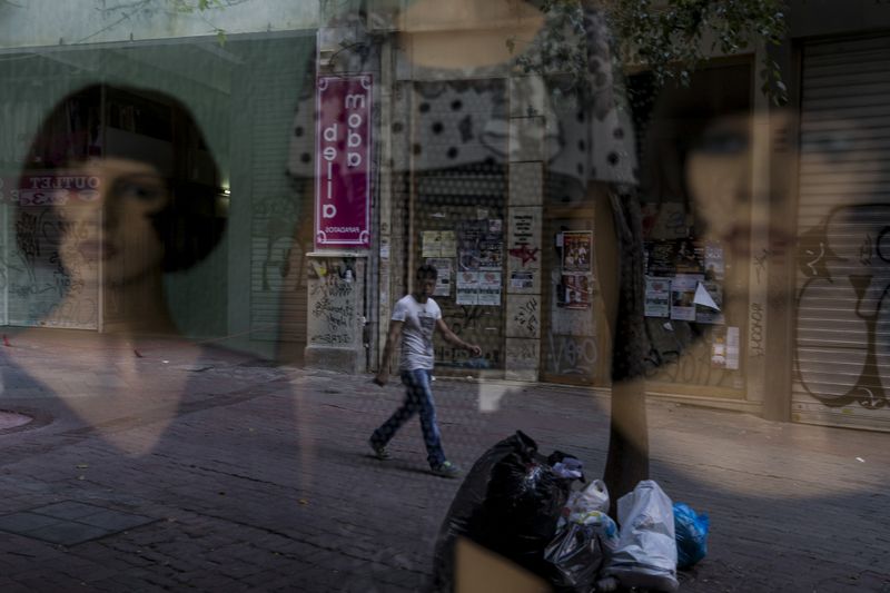&copy; Reuters. A man walks past a closed shop on a street in Athens