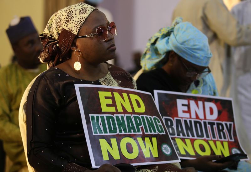 &copy; Reuters. A demonstrator holds a sign during a protest to urge authorities to rescue hundreds of abducted schoolboys, in northwestern state of Katsina