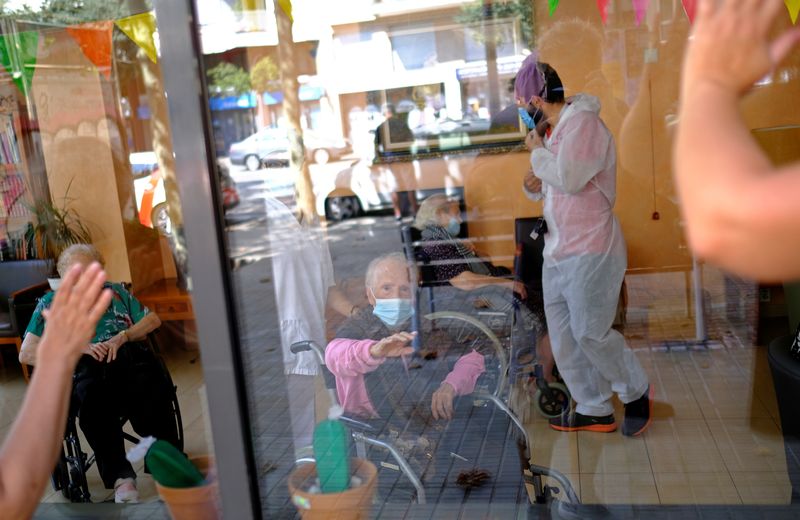 &copy; Reuters. FILE PHOTO: Elderly people get love through nursing home glass front as COVID surges