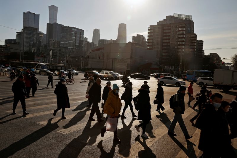 &copy; Reuters. Pessoas atravessam a rua em distrito empresarial de Pequim