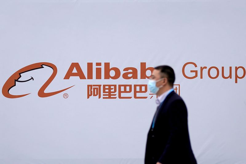&copy; Reuters. Imagen de archivo de una persona con mascarilla pasando frente al logo de Alibaba Group durante la Conferencia Mundial de Internet en Wuzhen, China.